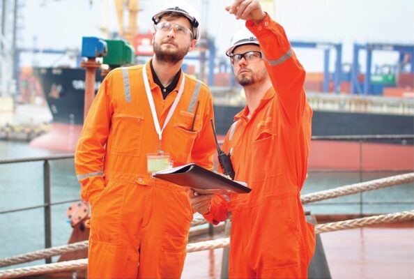 Workers in protective coveralls at a port